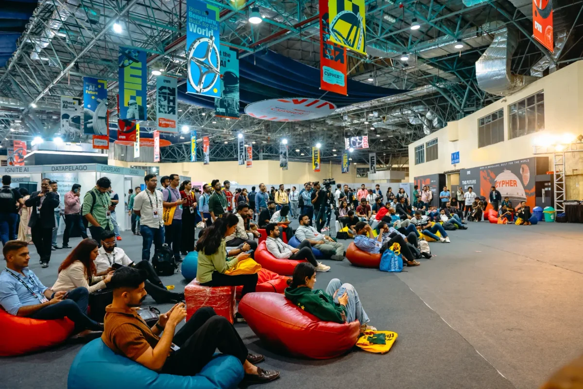 Attendees networking and exploring technology exhibits at the Cypher event, with AI and technology booths throughout the exhibition hall.