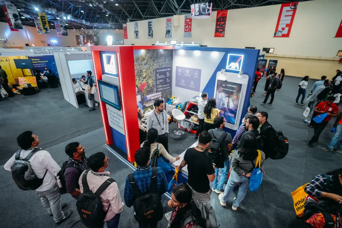 Attendees exploring an interactive technology booth at the Cypher event, with exhibitors demonstrating AI and automation solutions.